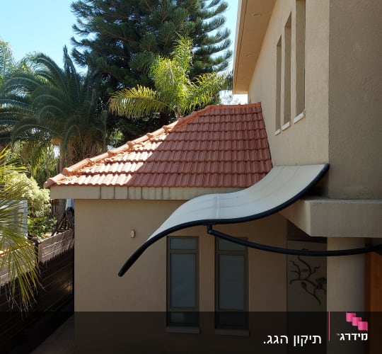 גג רעפים אדום עם קירוי לבן מעל חלונות